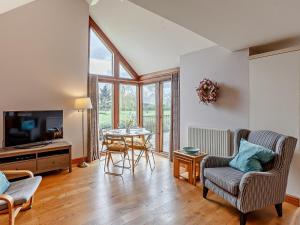 a living room with a table and chairs and a television at 1 Bed in Lydney oc-73584 in Saint Briavels