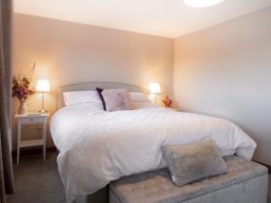 a bedroom with a large white bed and two lamps at 1 Bed in Lydney oc-73584 in Saint Briavels