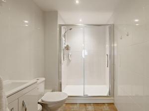 a white bathroom with a shower and a toilet at 1 Bed in Lydney oc-73584 in Saint Briavels +8 photos