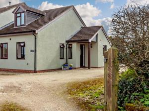 a white house with a fence in front of it at 1 Bed in Lydney oc-73584 in Saint Briavels