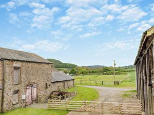 an old barn with a dirt road between two buildings at 1 Bed in Bucknell oc-94661 in Letton