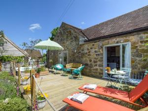 a wooden deck with chairs and an umbrella at 1 Bed in Kidderminster oc-94769 in Orleton