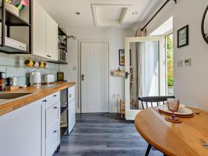 a kitchen with white cabinets and a wooden table at 1 Bed in Kidderminster oc-94769 in Orleton