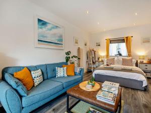 a living room with a blue couch and a bed at 1 Bed in Kidderminster oc-94769 in Orleton