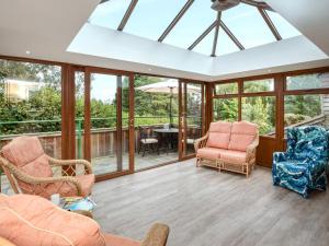 a conservatory with chairs and a table and windows at 1 Bed in Ludlow oc-chl23 in Orleton