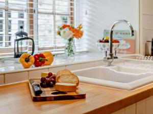 a kitchen counter with a cutting board with bread and fruit at 1 Bed in Frome oc-91715 in Woolverton +9 photos