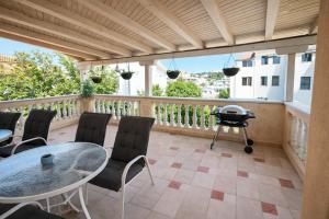 a balcony with a table and chairs and a grill at Orange city apartment's Repić in Biograd na Moru