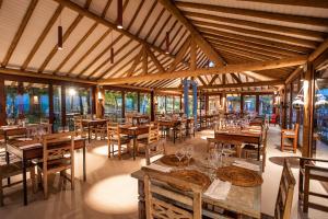 a dining room with wooden tables and chairs at La Torre Resort All Inclusive in Porto Seguro