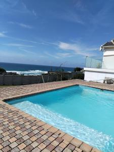 a blue swimming pool with the ocean in the background at Shotleft on Wye RD in Margate