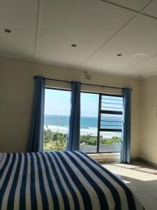 a bedroom with a large window with a view of the ocean at Shotleft on Wye RD in Margate +11 photos
