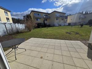 a patio with a bench in a yard with houses at Seeschwalbe in Graal-Müritz