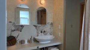 a bathroom with a white sink and two mirrors at トシマトビ in Toshima +16 photos