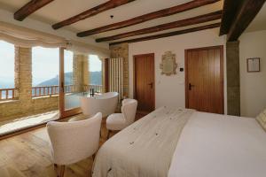 a bedroom with a bed and chairs and a balcony at Santa Llúcia Rupit in Rupit +142 photos