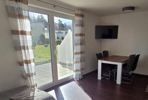 a room with a table and a television and a window at Seeschwalbe in Graal-Müritz