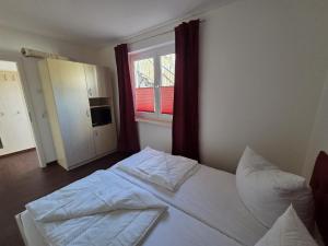 a bedroom with a white bed and a window at Seeschwalbe in Graal-Müritz