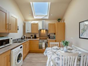 a kitchen with a table and a sink and a window at 2 Bed in Blakeney oc-54765 in Awre +7 photos