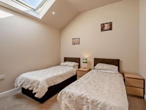 two beds in a bedroom with a window at 2 Bed in Blakeney oc-54765 in Awre