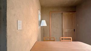 a room with a table and two chairs and a door at トシマトビ in Toshima