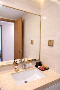 a bathroom with a sink and a large mirror at BRG Luxury Apartments in Hai Phong +18 photos