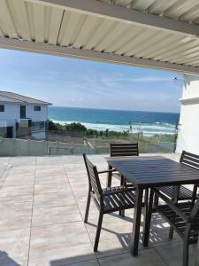 a patio with a table and chairs and the ocean at Shotleft on Wye RD in Margate