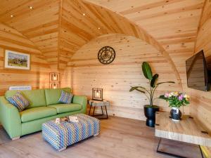 a living room with a green couch and a wooden ceiling at 1 Bed in Alfreton oc-90518 in South Wingfield
