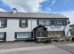a building with two picnic tables in front of it at Surfers Getaway - Room Staycation in Sligo +20 photos