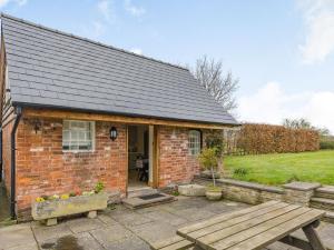 a brick cottage with a picnic table and a bench at 1 Bed in Hereford oc-87736 in Moccas