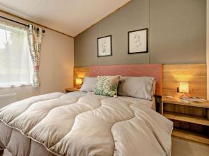 a large bed in a bedroom with two lamps at 3 Bed in Shrewsbury oc-94112 in Bromlow