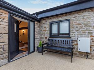 a bench sitting in front of a brick building at 2 Bed in High Peak oc-94058 in New Mills