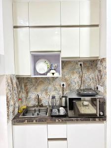 a kitchen with white cabinets and a microwave at The dream studio in Noida