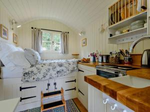 a small kitchen with white cabinets and a window at 1 Bed in Hereford oc-93441 in Little Dewchurch