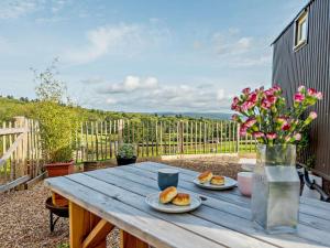 a wooden table with two plates of food on it at 1 Bed in Hereford oc-93441 in Little Dewchurch