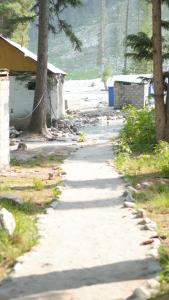 a path leading to a beach with trees and houses at Baba Jani Kumrat in Tāl +2 photos