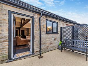 a brick house with a bench in front of it at 2 Bed in High Peak oc-94059 in New Mills