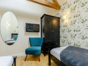 a bedroom with a bed and a chair and a mirror at 2 Bed in Evesham oc-89305 in Church Lench