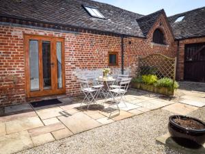 a patio with a table and chairs in front of a brick building at 2 Bed in Evesham oc-89305 in Church Lench