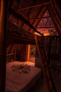 a room with a bed in a wooden building at Muluk Grove Lodge in Placencia