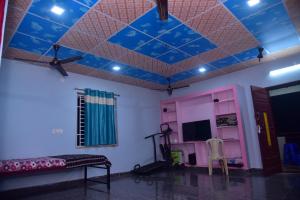 a room with a blue ceiling and a bed at Sripadakuteer in Pithāpuram