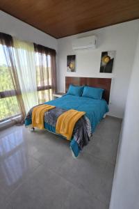 a bedroom with a bed with a blue comforter at GK Luxury Stay in Cruce de Veragua
