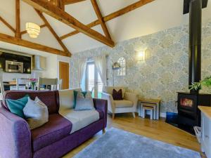 a living room with a purple couch and a fireplace at 1 Bed in Evesham oc-89306 in Church Lench +13 photos