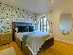 a bedroom with a bed with blue pillows and a mirror at 1 Bed in Evesham oc-89306 in Church Lench