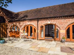 a brick house with a patio with a table and chairs at 1 Bed in Evesham oc-89306 in Church Lench