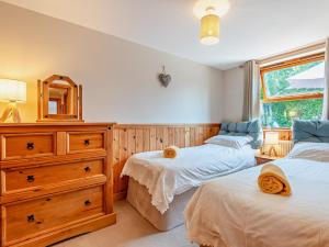 a bedroom with two beds and a dresser and a mirror at 2 Bed in Ledbury oc-77377 in Yatton
