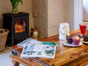 a wooden coffee table with a book and a fireplace at 2 Bed in Evesham oc-49245 in Cleeve Prior