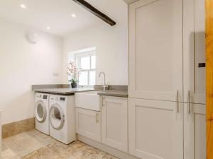 a white kitchen with a washing machine and a sink at 1 Bed in Hope Valley oc-89720 in Hope +12 photos