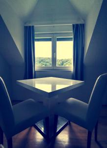 a table and two chairs in front of a window at VILLa LIKA A NNEX in Plitvička Jezera