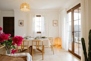 a white dining room with a table and chairs at Villa Volcano by CasasBlancas in Yaiza
