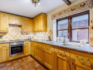 a kitchen with wooden cabinets and a sink and a window at 2 Bed in Shrewsbury oc-86590 in Leighton +9 photos