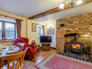 a living room with a brick fireplace and a table and chairs at 2 Bed in Shrewsbury oc-86590 in Leighton
