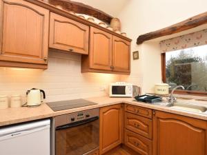 a kitchen with wooden cabinets and a microwave at 2 Bed in Hope Valley oc-pk431 in Aston +6 photos